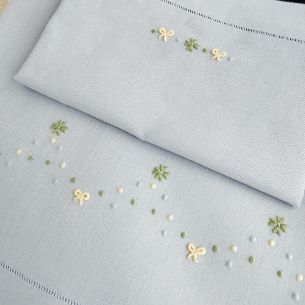 Lenzuolino celeste con fiocchi  e quadrifoglio